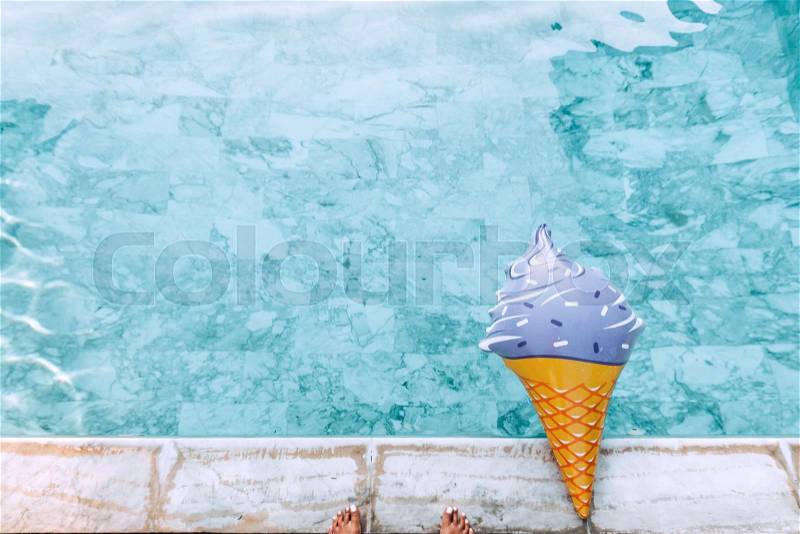 Ice cream pool float in blue water. Photo of inflatable toy from above, stock photo