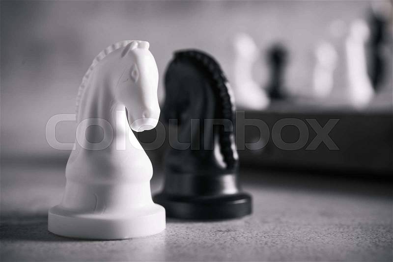 Chess knight horse on the chessboard, stone background, stock photo
