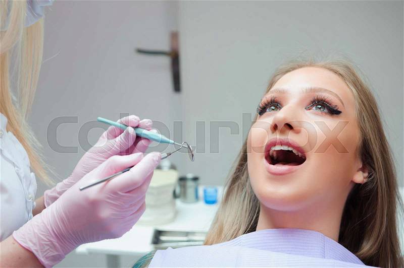 Young woman having medical checkup in the dentist office by the doctor, stock photo