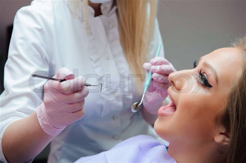 Young woman having medical checkup in the dentist office by the doctor, stock photo