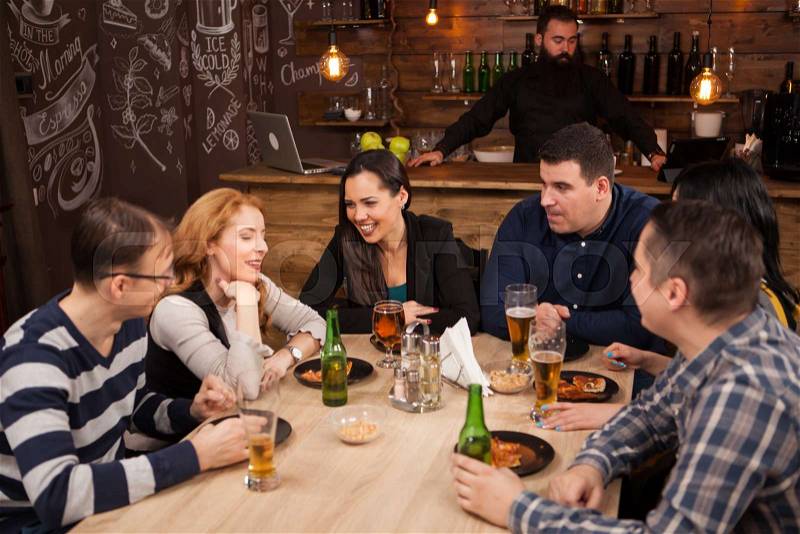 Old friends having fun in an old styled pub. Meeting in a hipster pub, stock photo