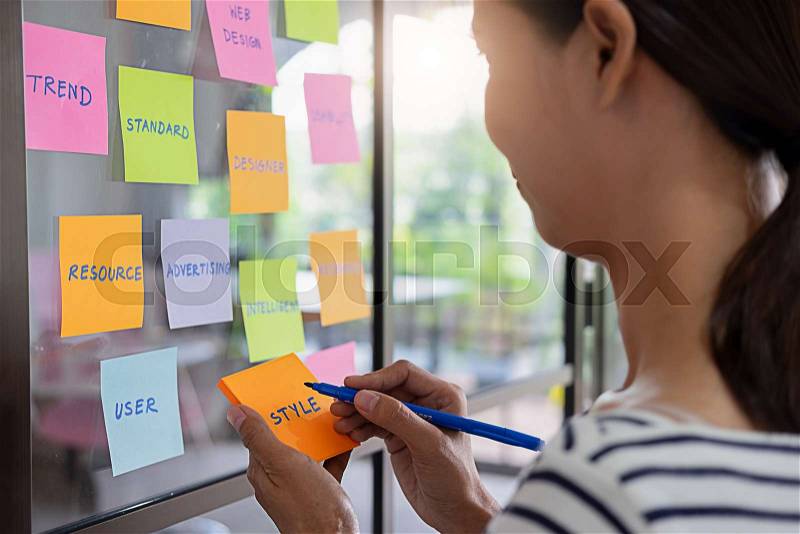 Web designer brainstorming for a strategy plan. Colorful sticky notes with things to do on office board. User experience (UX) concept, stock photo