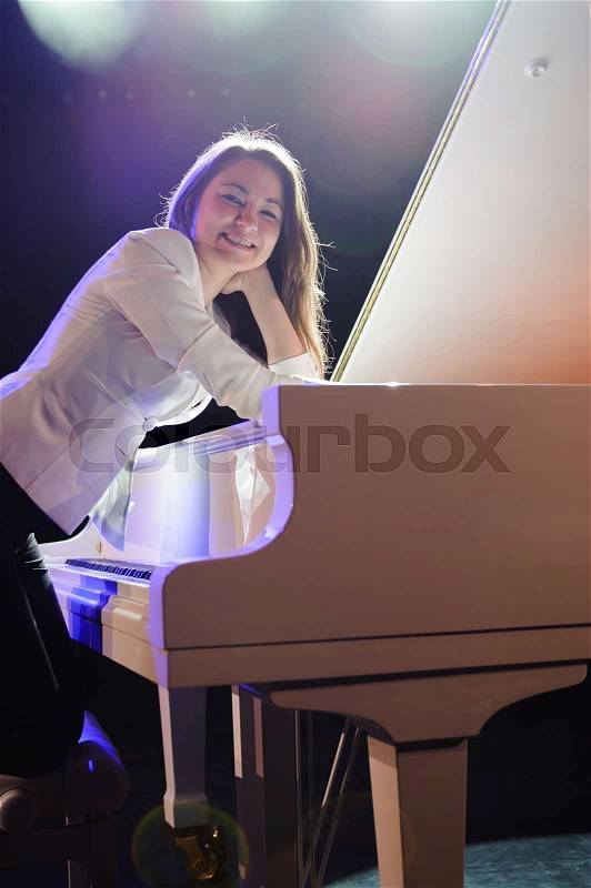 Woman with the white piano on the stage, stock photo