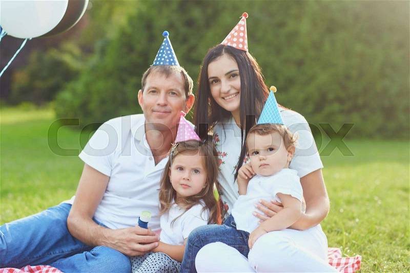 Parents wish children a happy birthday in the park in the summer, stock photo
