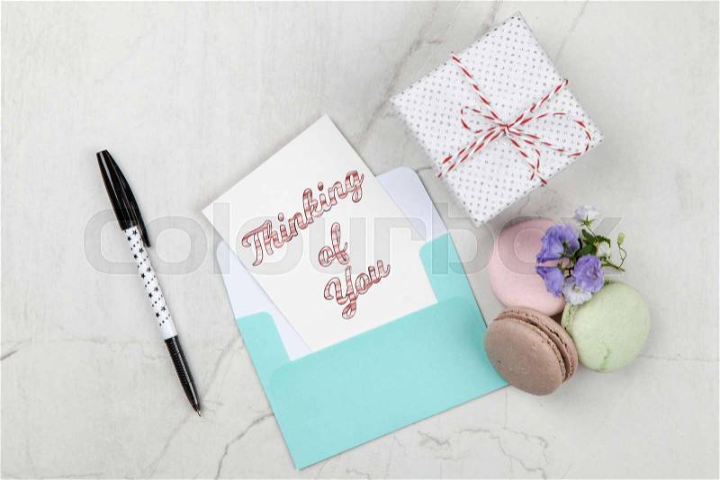 Thinking of You postcard note on white marble table, stock photo