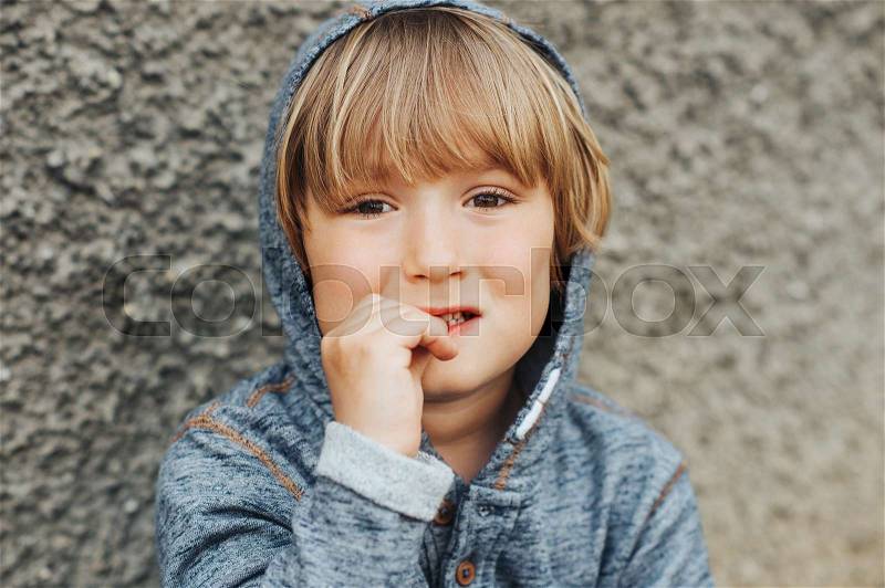 Stressed child biting finger nails, sad toddler boy, stock photo