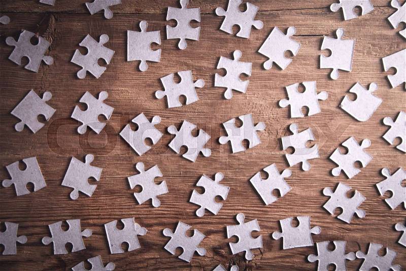 Pieces of the jigsaw puzzles on wooden background. , stock photo