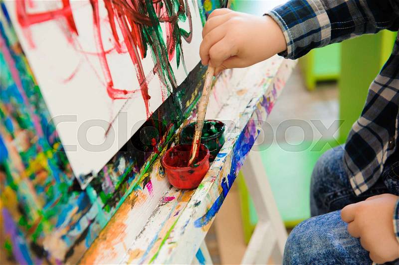 A child draws a picture paints on art lesson, stock photo