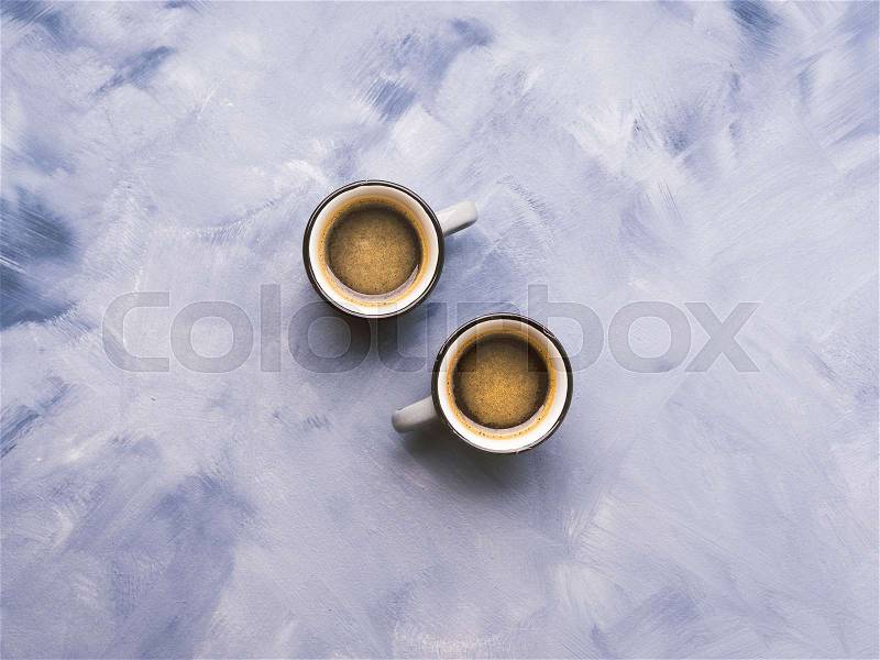 Two coffee cups on sky blue painted background. Minimal flat lay, stock photo