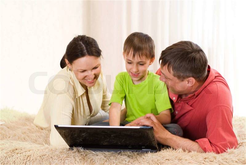 Family of three with a laptop, stock photo