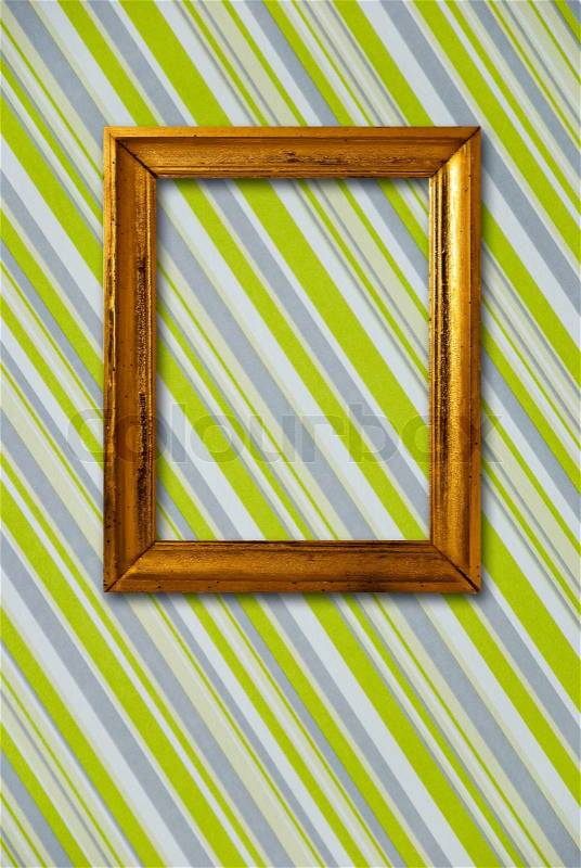 Gold frame on striped vintage wallpaper background, stock photo