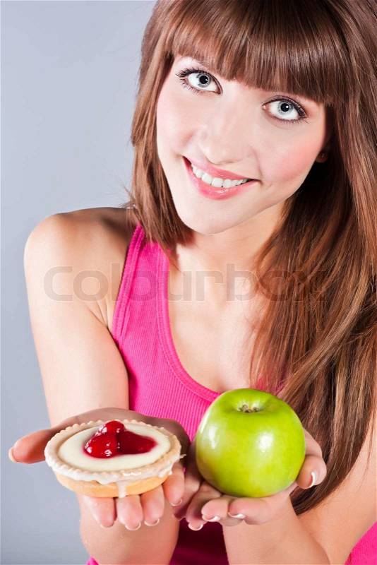 Woman with apple and cake in hands, stock photo
