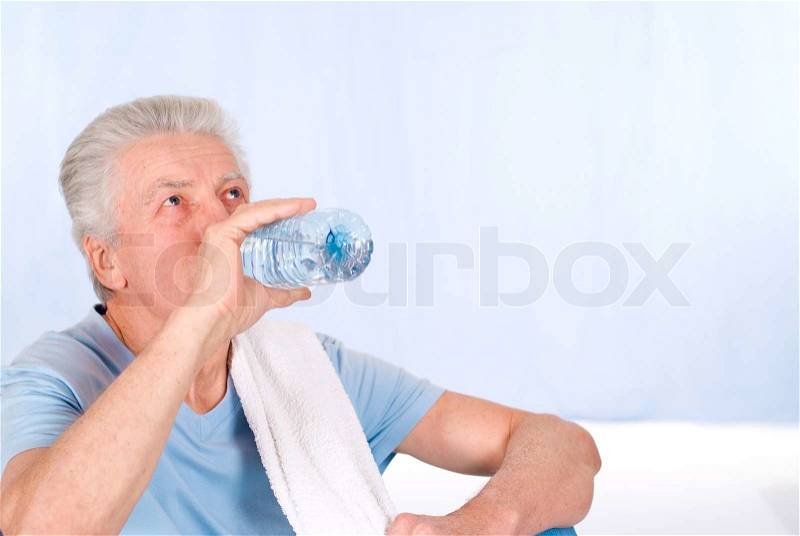Old man drinks water, stock photo