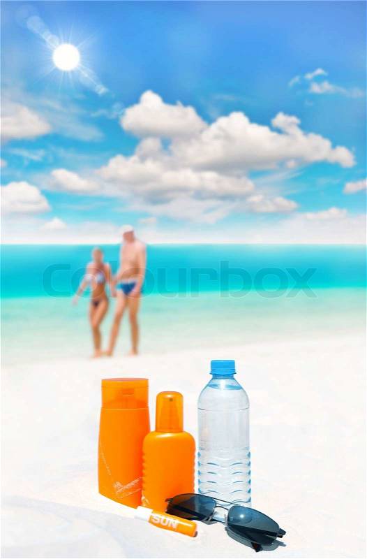 Sun protection cream, bottle of water and sun glasses, stock photo