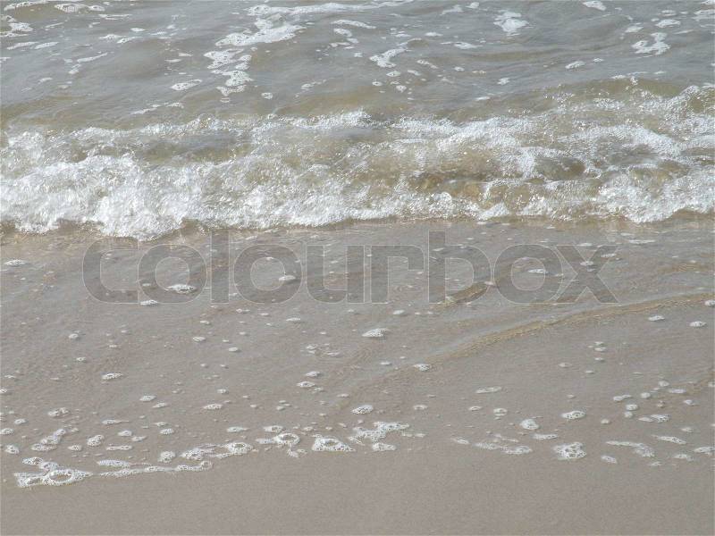 Close up sea water rolling onto beach at north sea, stock photo