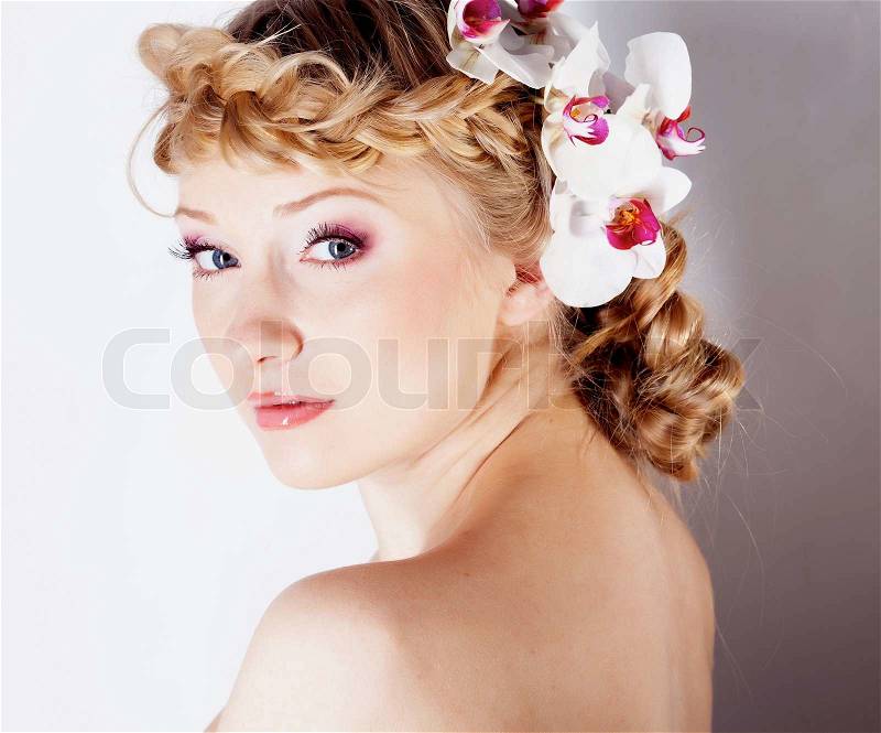 Girl with orchid flower in hair, stock photo