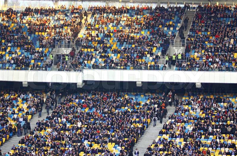 KYIV, UKRAINE - MARCH 18, 2012: People watch the football game of Ukraine Championship between FC Dynamo Kyiv and FC Dnipro at NSC Olimpiyskiy stadium on March 18, 2012 in Kyiv, Ukraine, stock photo