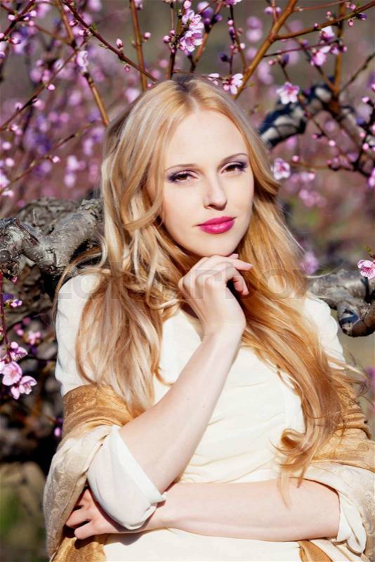 Beautiful young woman in peach garden, stock photo