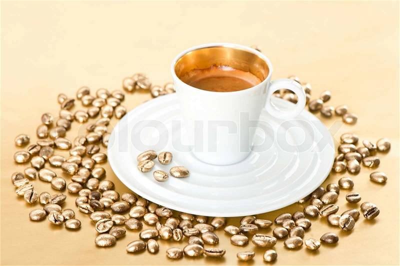 Cup of black coffee with golden coffee beans, stock photo
