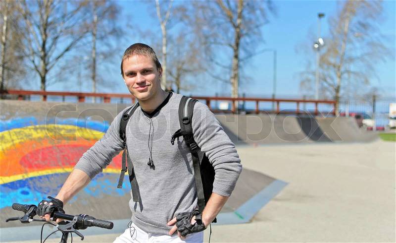 Portrait of BMX bicycle rider on urban skatepark background, stock photo