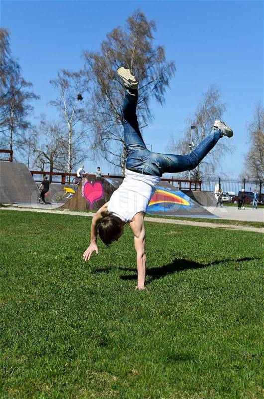 Breakdancer doing a flip on the grass, stock photo
