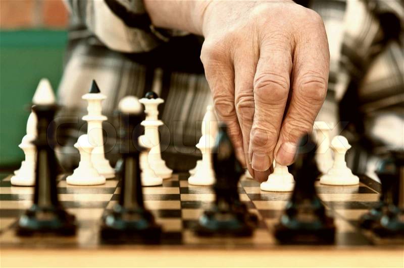 Old man playing chess, stock photo