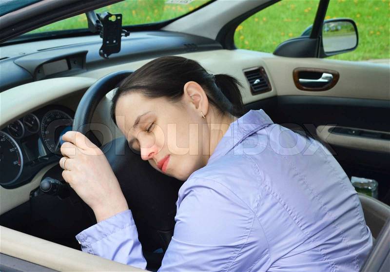 Young girl sleeps in her car, stock photo