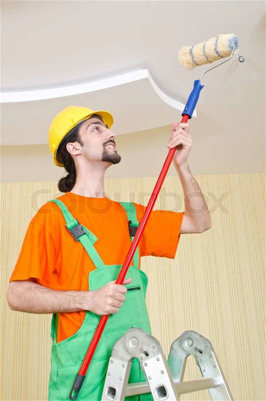 Painter worker during painting job, stock photo