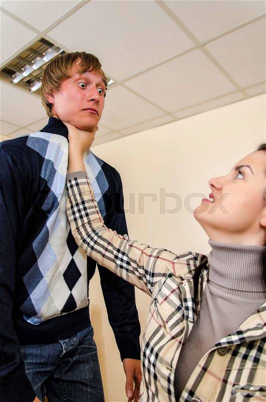 Office fight: Woman trying to stifle a man, stock photo