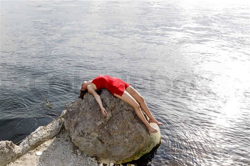 Young woman lying on rock, stock photo