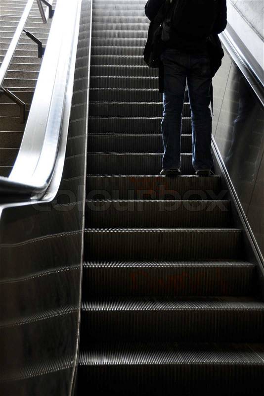 Man moving up with escalator, stock photo