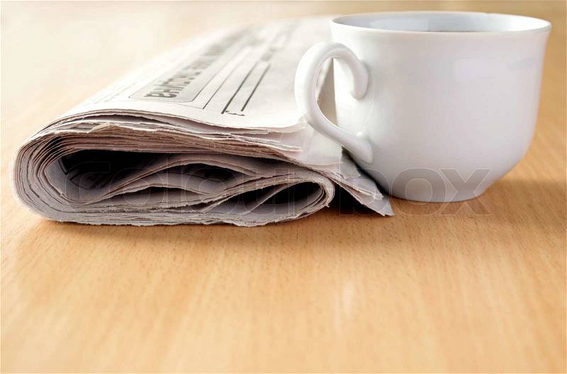 Cup of coffee and the newspaper on the table, stock photo