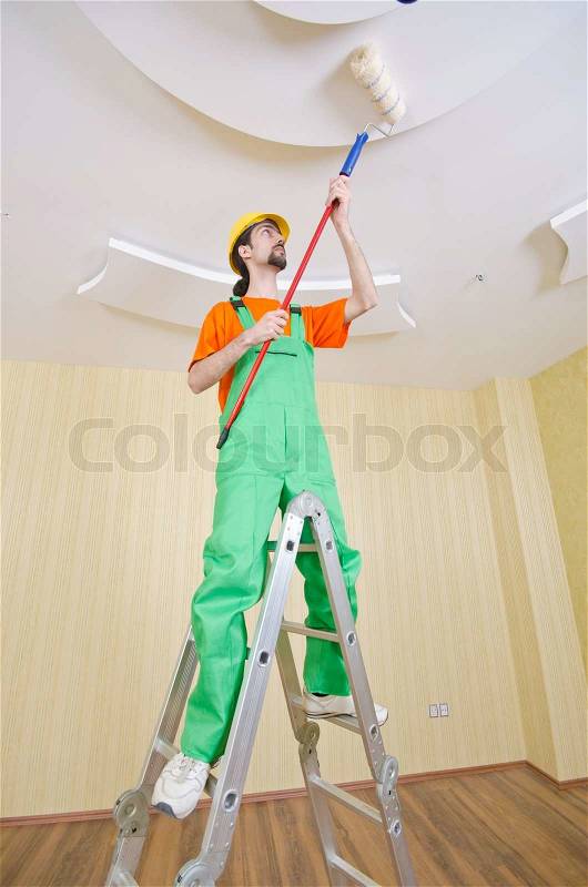 Painter worker during painting job, stock photo