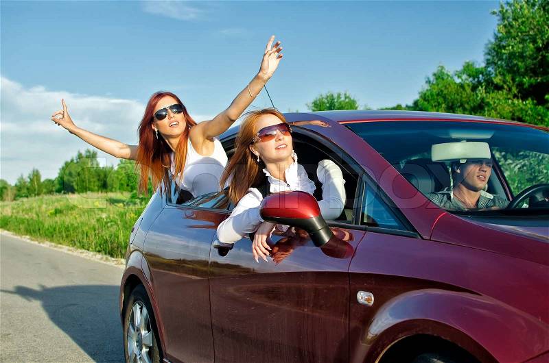 Two pretty happy girls in the car Concept of carefree roadtrip, stock photo