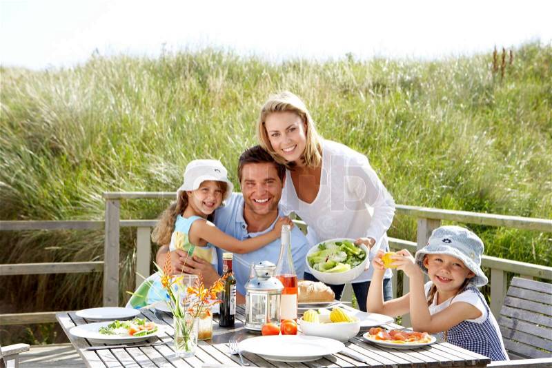Family on vacation eating outdoors, stock photo