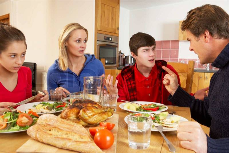 Teenage Family Having Argument Whilst Eating Lunch Together In Kitchen, stock photo