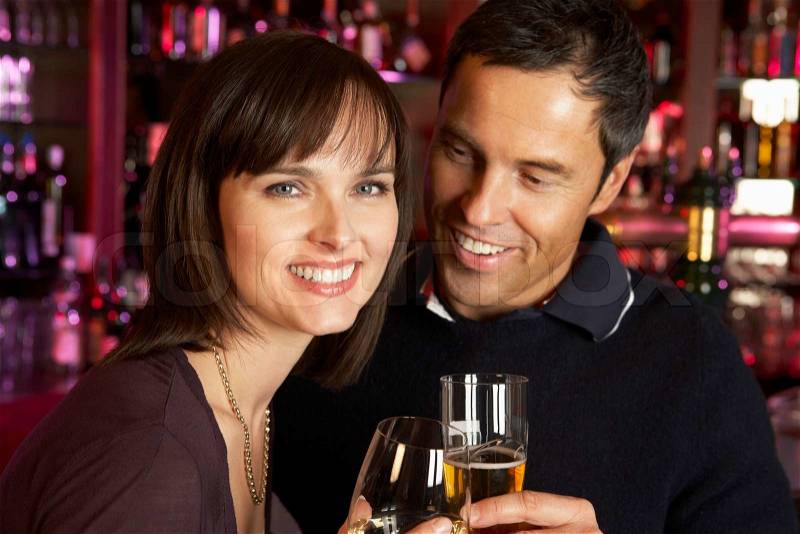 Couple Enjoying Drink Together In Bar, stock photo
