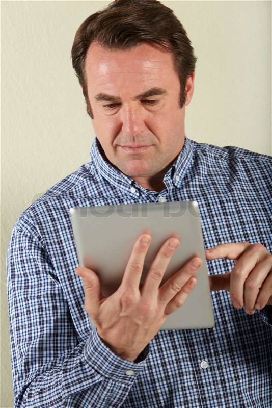 Studio Shot Of Middle Aged Man Using Tablet Computer, stock photo