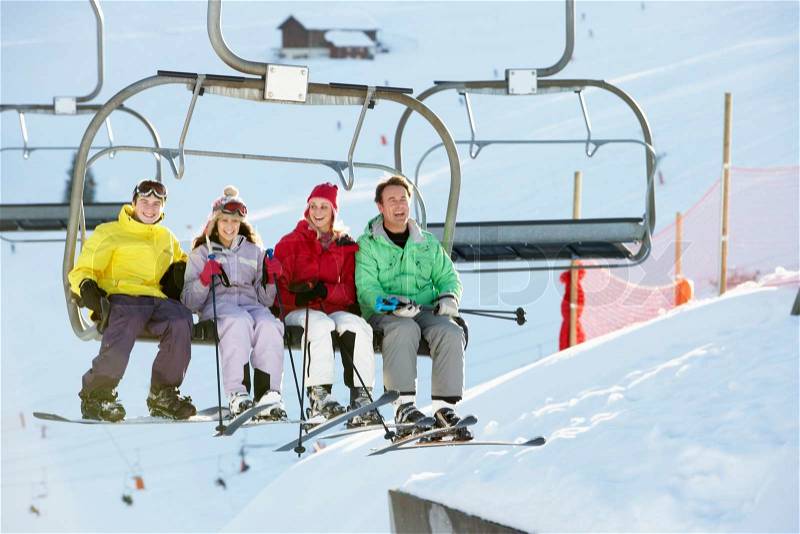 Teenage Family Getting Off chair Lift On Ski Holiday In Mountains, stock photo