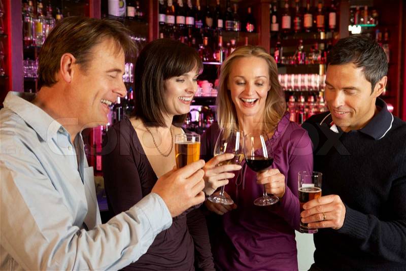 Group Of Friends Enjoying Drink Together In Bar, stock photo