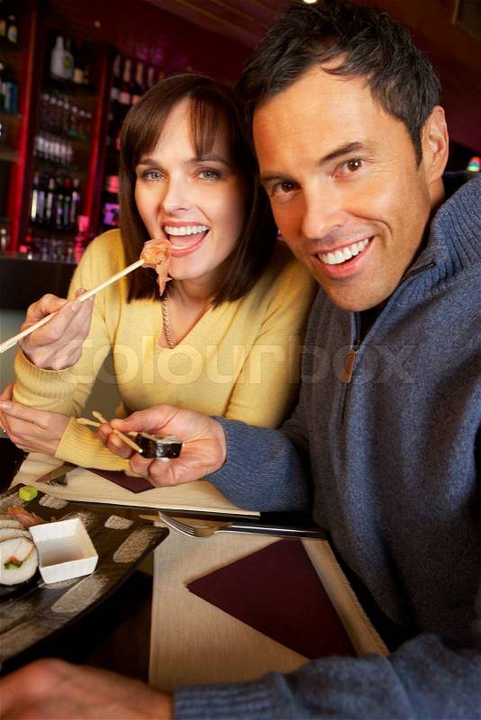 Couple Enjoying Sushi In Restaurant, stock photo