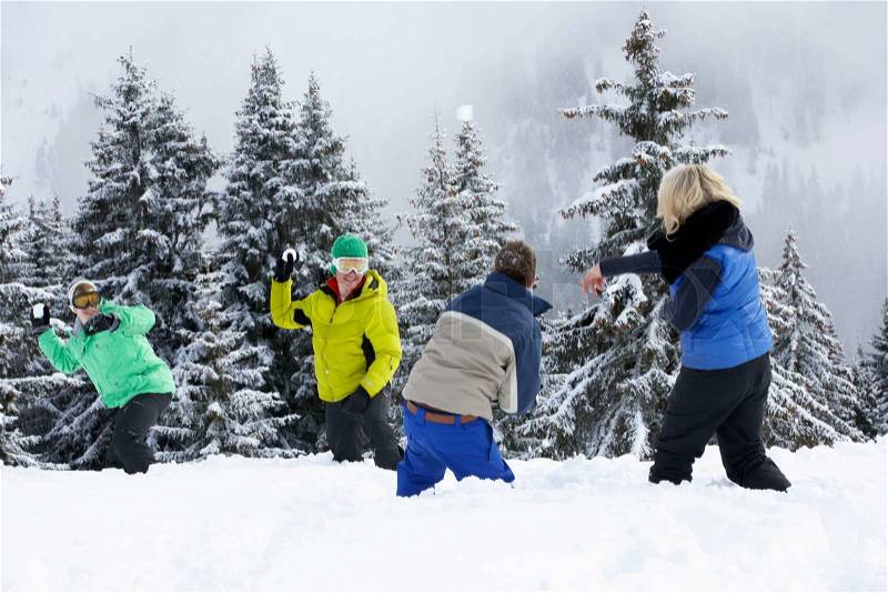 Group Of Young Friends Having Snowball Fight On Ski Holiday In Mountains, stock photo