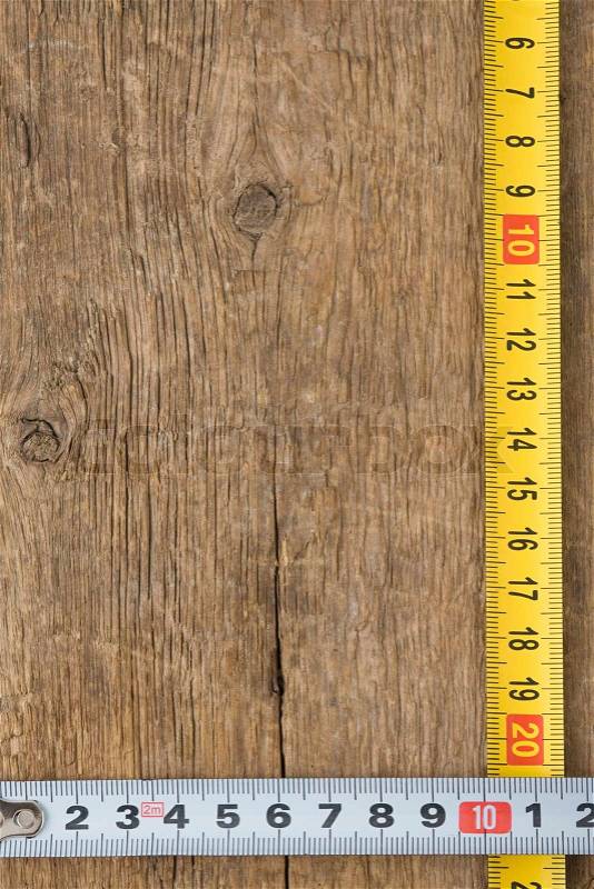 Tape measure on wood texture, stock photo