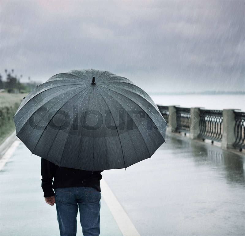Rain and lonely man with umbrella, stock photo