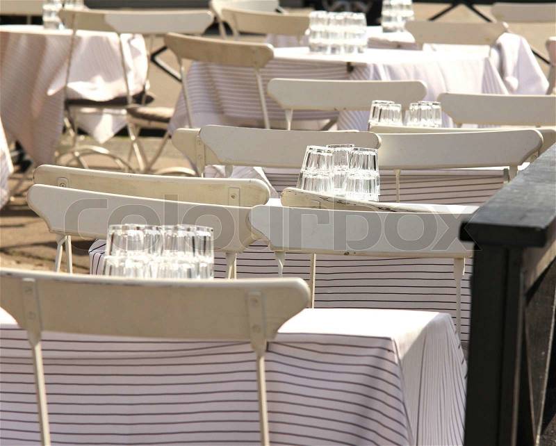 White chairs and tables, outdoors at a restaurant, stock photo