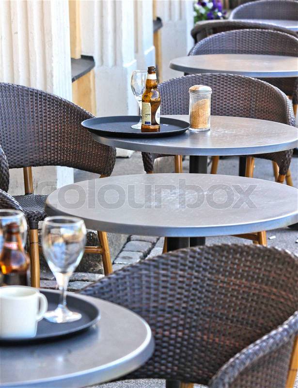 Restaurant outdoors, beer bottle on table, nobody around, stock photo