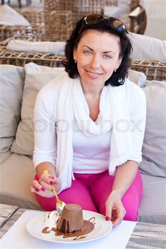 Woman eating delicious dessert in a cafe bistro, stock photo