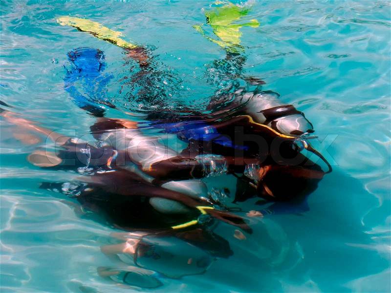 A boy taking scuba diving lessons in the caribbean resort, stock photo