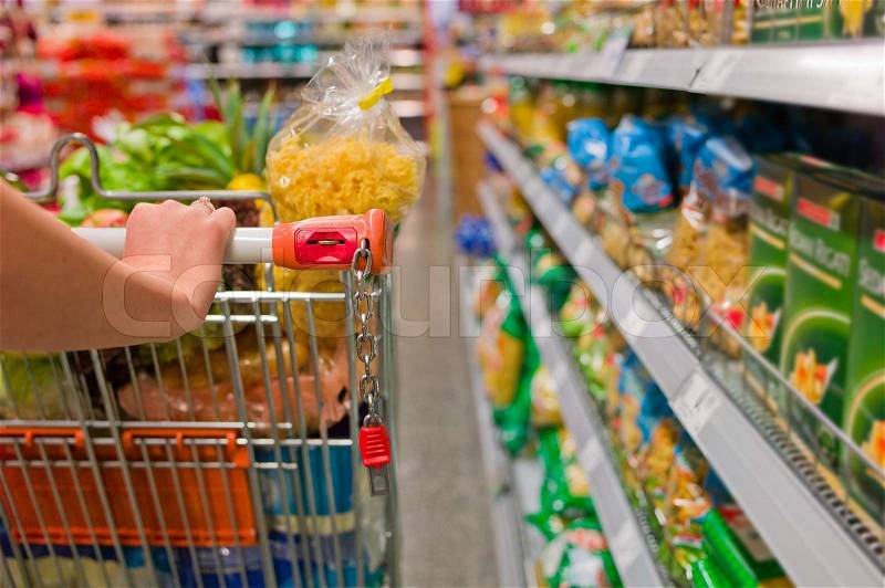 Woman with shopping cart in the supermarket, stock photo