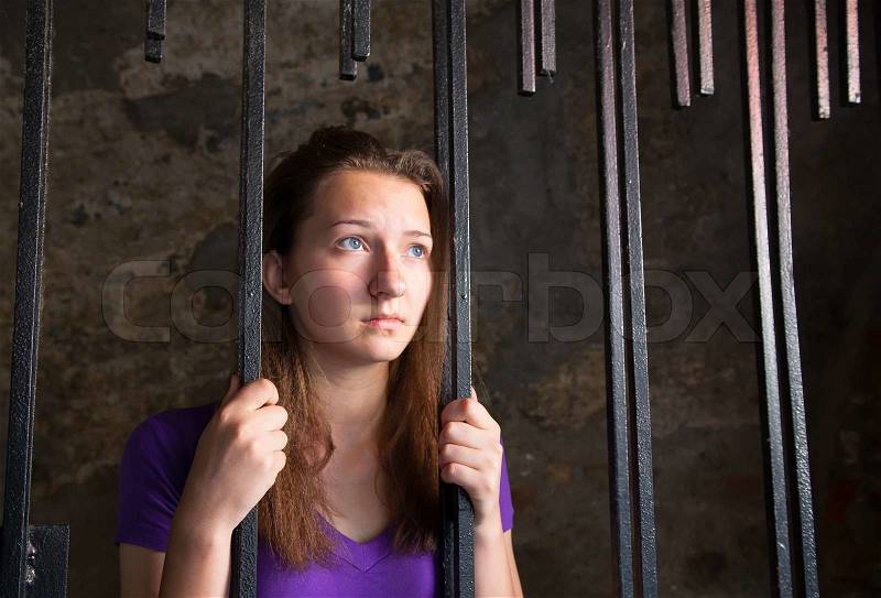 Young woman behind the bars, stock photo